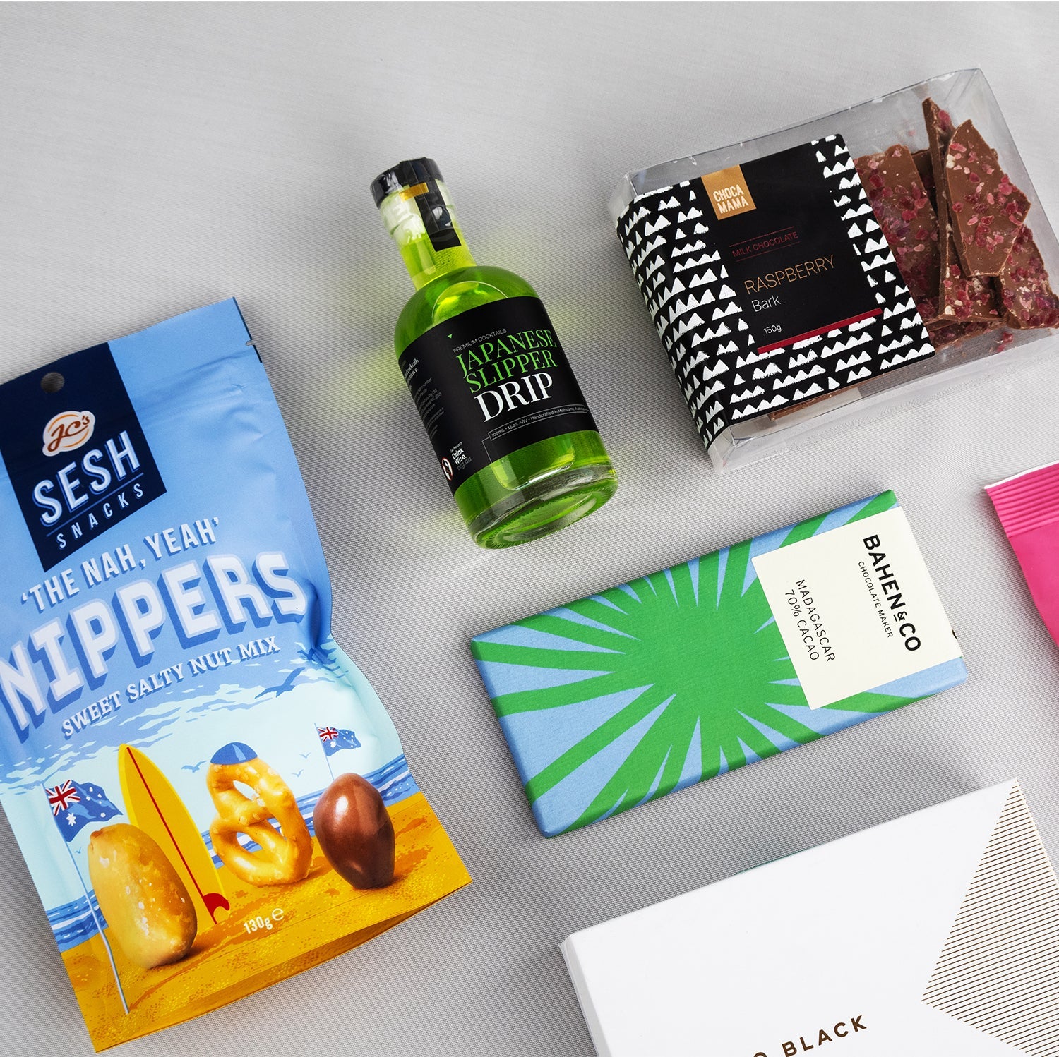 Blue bag of Sesh The Nak Neppers, small green bottle of Drup spirit, green and blue patterned Damelco chocolate bar, black.