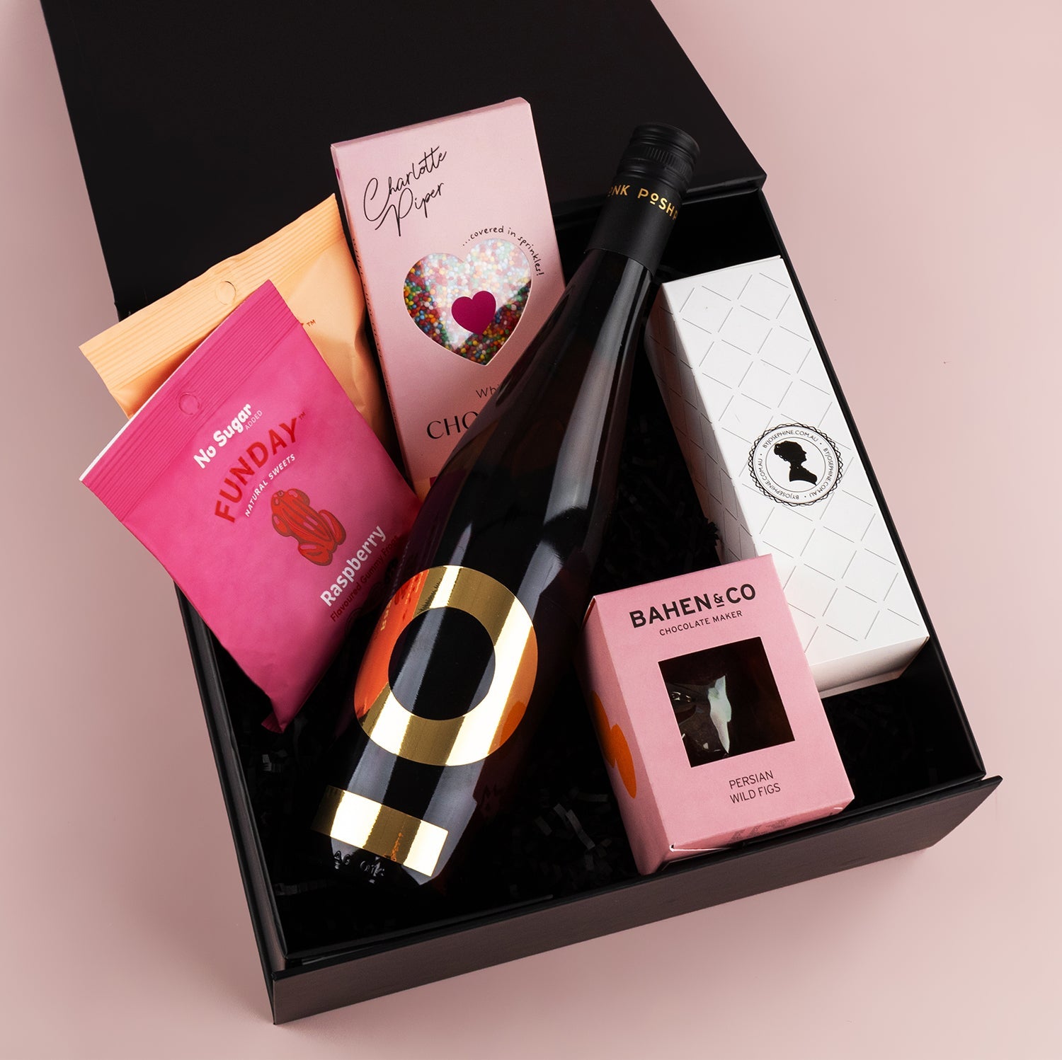 Black gift box with Posh Plonk Pinot Grigio bottle, pink chocolate bar, pink coffee pack, pink Bamenco chocolate box, and.