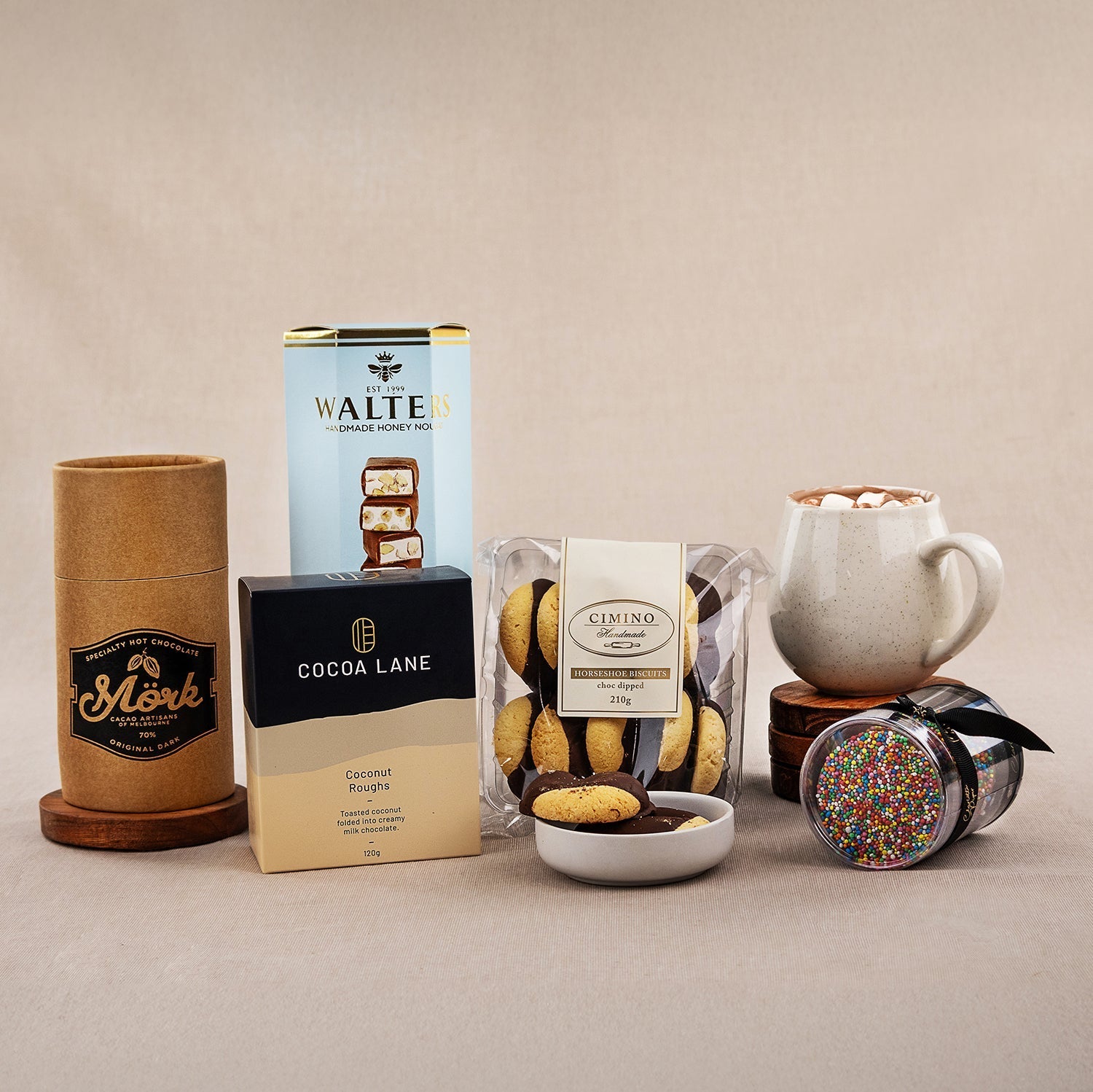 Chocolate Delight Hamper with assorted chocolates, vanilla cookies, hot chocolate mix, and a ceramic mug with whipped cream.